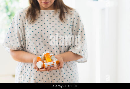 Femme avec des bouteilles de pilules dans les mains Banque D'Images