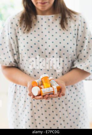 Femme avec des bouteilles de pilules dans les mains Banque D'Images