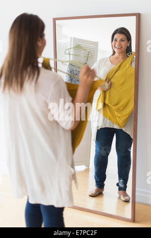 Woman holding nouvelle robe et à miroir à Banque D'Images