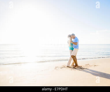 Mature couple dancing on beach Banque D'Images