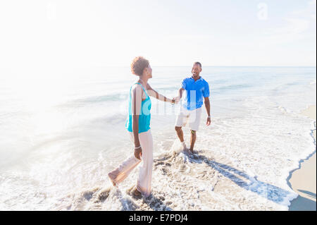 Mature couple walking on beach Banque D'Images