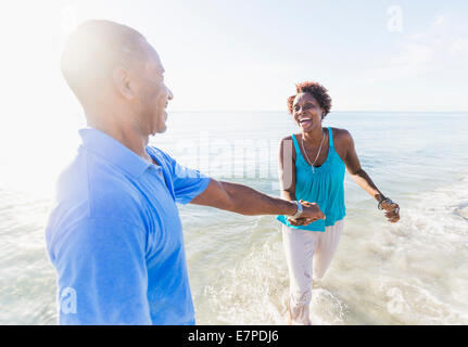 Mature couple walking on beach Banque D'Images