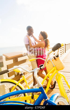 USA, Floride, Jupiter, Young couple embracing on boardwalk Banque D'Images