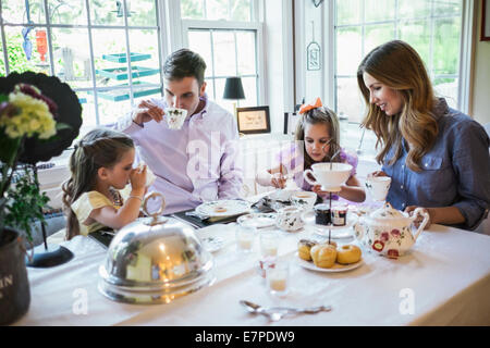 Les parents et la fille (4-5) manger ensemble dans la salle à manger Banque D'Images