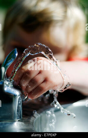 Un jeune garçon (2 1/2 ans) jouant avec une fontaine d'eau Banque D'Images