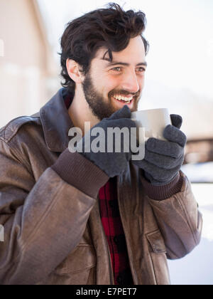 Portrait of man holding coffee mug à l'extérieur en hiver Banque D'Images