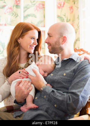 Parents tenant leur bébé endormi (2-5 mois) Banque D'Images
