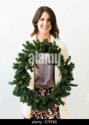 Studio shot of woman holding Christmas wreath Banque D'Images