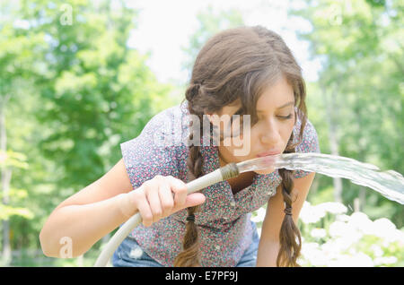 Femme de l'eau potable tuyau de jardin Banque D'Images