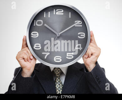 Close up of businessman couvrant son visage avec horloge analogique isolé sur fond gris Banque D'Images