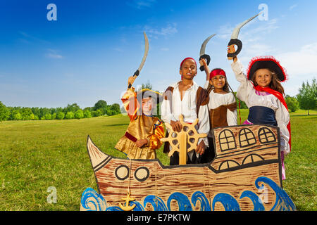 Quatre enfants en costumes Pirate Ship derrière Banque D'Images