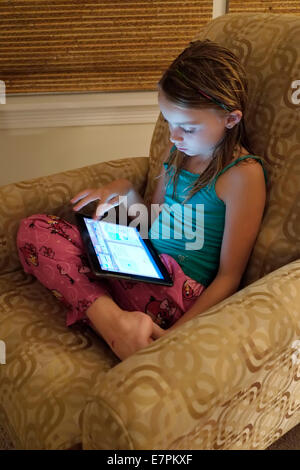 Girl doing homework école sur un ordinateur Tablet Banque D'Images