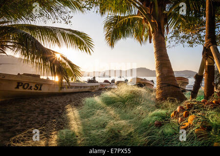 Filets de Pêches et bateaux sur la plage au lever du soleil à Zihuatanejo, Guerrero, Mexique. Banque D'Images