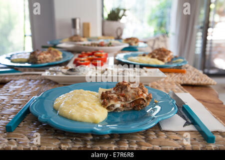 Lasagne maison et sa purée de pommes de terre dans une assiette sur la table à manger Banque D'Images