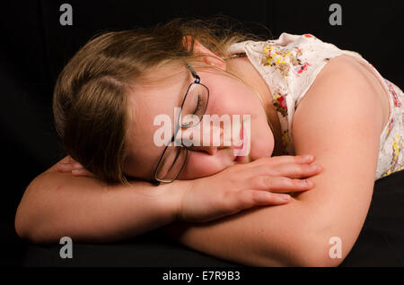 Image d'une fillette de 8 ans dormir sur un fond noir Banque D'Images