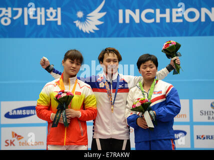 Incheon, Corée du Sud. Sep 23, 2014. Médaillé d'or Tzn Lin Chi (C) du Taipei chinois, de l'argent olympique Deng Wei (L) de la Chine, médaillée de bronze aux JO et Pokhyang de République populaire démocratique de Corée (RPDC) posent sur le podium lors de la cérémonie de la féministe 63kg d'haltérophilie aux 17e Jeux asiatiques à Incheon, Corée du Sud, 23 septembre 2014. Tzn Lin Chi a battu le records du monde de l'événement par une élévation totale de 261kg, et Clean & jerk avec 145kg. © Ma Ping/Xinhua/Alamy Live News Banque D'Images