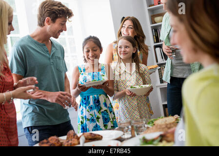 Une réunion de famille pour un repas. Les adultes et les enfants autour d'une table. Banque D'Images