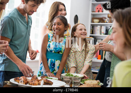 Une réunion de famille pour un repas. Les adultes et les enfants autour d'une table. Banque D'Images