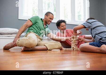 Sur le plancher de la famille jouent à un jeu à la maison. Banque D'Images