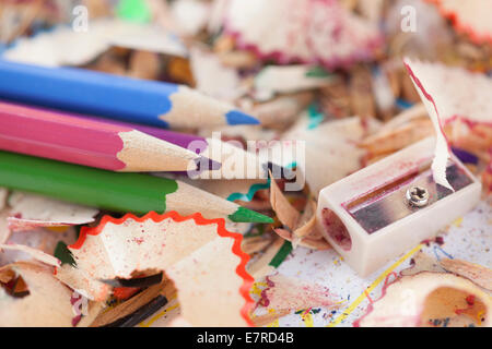 Crayons de couleur avec des copeaux de crayon et taille-crayon. Banque D'Images