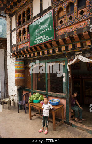 L'est du Bhoutan, Trashigang, Duksum, bazar, l'enfant à l'extérieur Norgay Bakery Banque D'Images