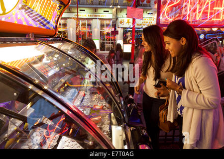 Deux femmes jouant des jeux de hasard dans une salle de jeux électroniques, Soho, Londres UK Banque D'Images