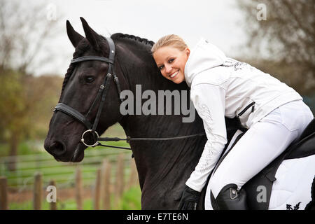 Cheval frison ou frisons, étalon, English bridle, avec femelle cavalier au cheval Banque D'Images