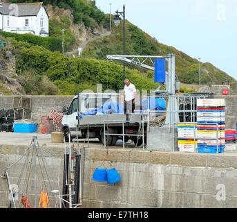 Un homme sur un camion à l'aide d'un palan pour soulever les captures d'un chalutier de pêche Newquay Cornwall England uk Banque D'Images