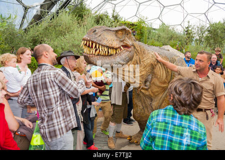 Un dinosaure en liberté (avec les gardiens) divertit les enfants et familles à l'Eden Project à Bodelva Saint Austell, Cornwall, UK Banque D'Images