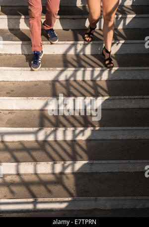 Les ombres jouer comme un couple descend un escalier Banque D'Images