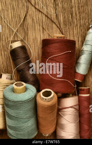 De nombreux rouleaux de coton de couleur sur un fond de bois. Banque D'Images