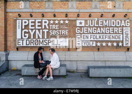 Les femmes assises par le programme du Théâtre National, publicité Peer Gynt d'Ibsen. Oslo, Norvège Banque D'Images