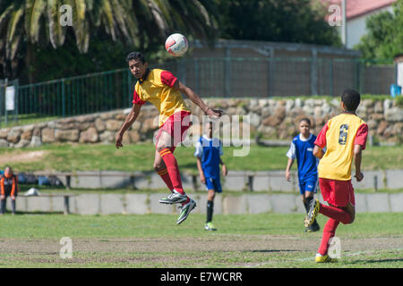 Jeunes joueurs de football de sauter à la tête de la balle, Le Cap, Afrique du Sud Banque D'Images