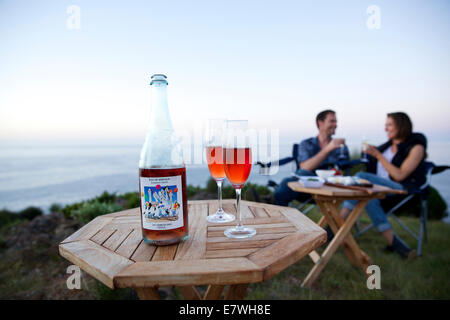 Un couple ayant un apéritif au coucher du soleil sur la falaise, Snug Cove, l'île kangourou en Australie Banque D'Images