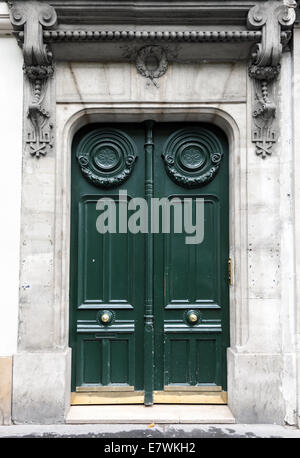 Porte en bois vert foncé dans la vieille façade de l'immeuble. Paris, France Banque D'Images