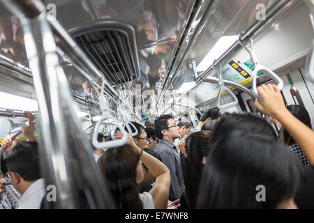 Les banlieusards monter un train de banlieue bondé à Singapour. Banque D'Images