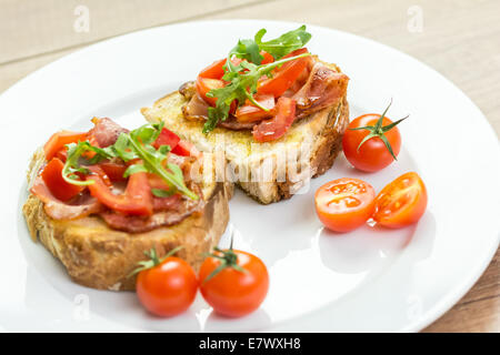 Sandwich Bruschetta fraîche au bacon, tomates et roquette Banque D'Images