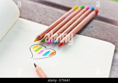 Coeur coloré de crayons de couleur sur la page de l'ordinateur portable Banque D'Images