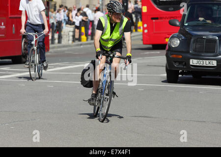 Les cyclistes voyageant sur une route de Londres. L'un allant autour de la courber l'autre d'aller tout droit. Banque D'Images