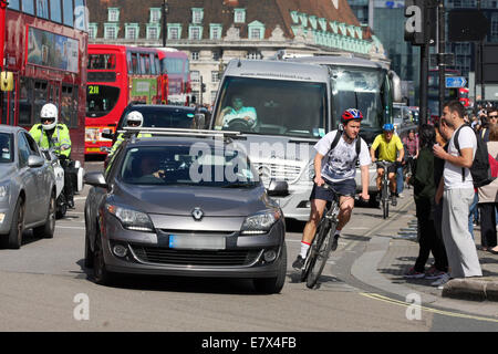 Les véhicules circulant autour d'un coude en place du Parlement, Londres. Attendre les piétons de traverser la route. Banque D'Images