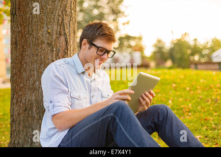 Smiling male student en lunettes avec tablet pc Banque D'Images