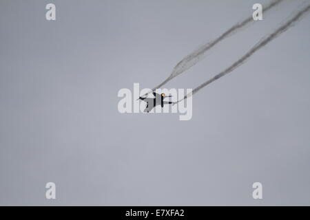 Palaio Faliro, Grèce. 25 septembre 2014. Un F-16 Fighting Falcon de l'Armée de l'air belge crée des traînées de vapeur brune qu'il survole la mer à Palaio Faliro. Les affichages publics du spectacle aérien de Tatoi, qui fait partie de la 3e semaine de vol Athènes a commencé avec un pré-show avec fly off à la côte de Palaio Faliro près d'Athènes. Crédit : Michael Debets/Alamy Live News Banque D'Images