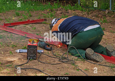 Travailler dans la maison rurale. Production d'une clôture et la porte de fer. La soudure du fer à repasser coin. Banque D'Images