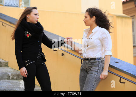 Deux copines, adolescents, arguant sur un escalier, Menton, Alpes-Maritimes, Provence-Alpes-Côte d'Azur, France Banque D'Images