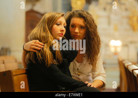 Deux copines, adolescents, assis dans une église, l'un englobant les autres, Menton, Alpes-Maritimes, Provence-Alpes-Côte d'Azur Banque D'Images