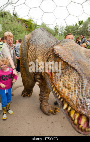 Un dinosaure en liberté (avec les gardiens) divertit les enfants et familles à l'Eden Project à Bodelva Saint Austell, Cornwall, UK Banque D'Images