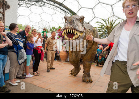 Un dinosaure en liberté (avec les gardiens) divertit les enfants et familles à l'Eden Project à Bodelva Saint Austell, Cornwall, UK Banque D'Images