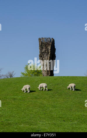 Trois ovins paissent sous ciel bleu profond au pied du 'bol en bronze avec dentelle' par Ursula von Rydingsvard - Yorkshire Sculpture Park, Angleterre, Royaume-Uni. Banque D'Images