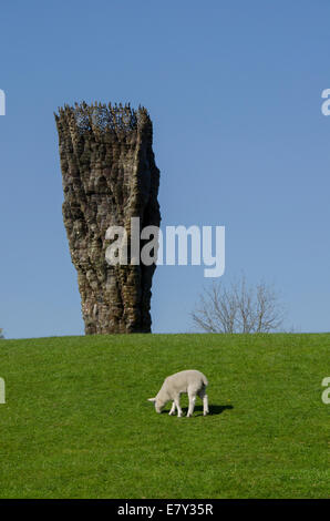 Les brebis ou d'agneau broute sous ciel bleu profond au pied du 'bol en bronze avec dentelle' par Ursula von Rydingsvard - Yorkshire Sculpture Park, Angleterre, Royaume-Uni. Banque D'Images