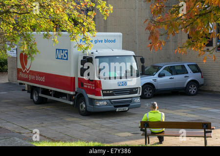 Red & White NHS Service de transplantation de sang et camion stationné dans un parking à l'extérieur d'un centre de don - Bingley, West Yorkshire, Angleterre, Royaume-Uni. Banque D'Images